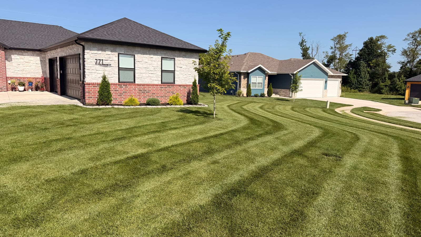 Fresh mowing stripes sweeping across a residential lawn cared for by Pebble Creek